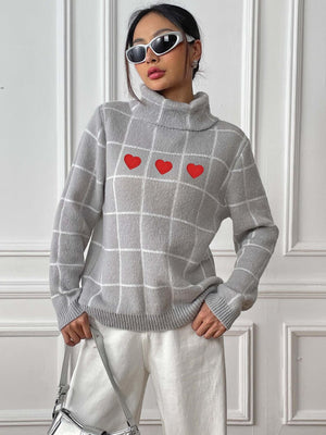 Light gray turtleneck sweater with white grid pattern and three red heart appliqués.