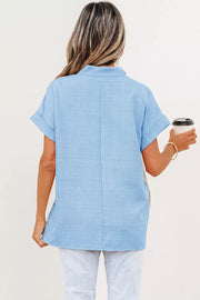 Blue polyester pullover maternity shirt with cuffed short sleeves and a subtle textured weave.