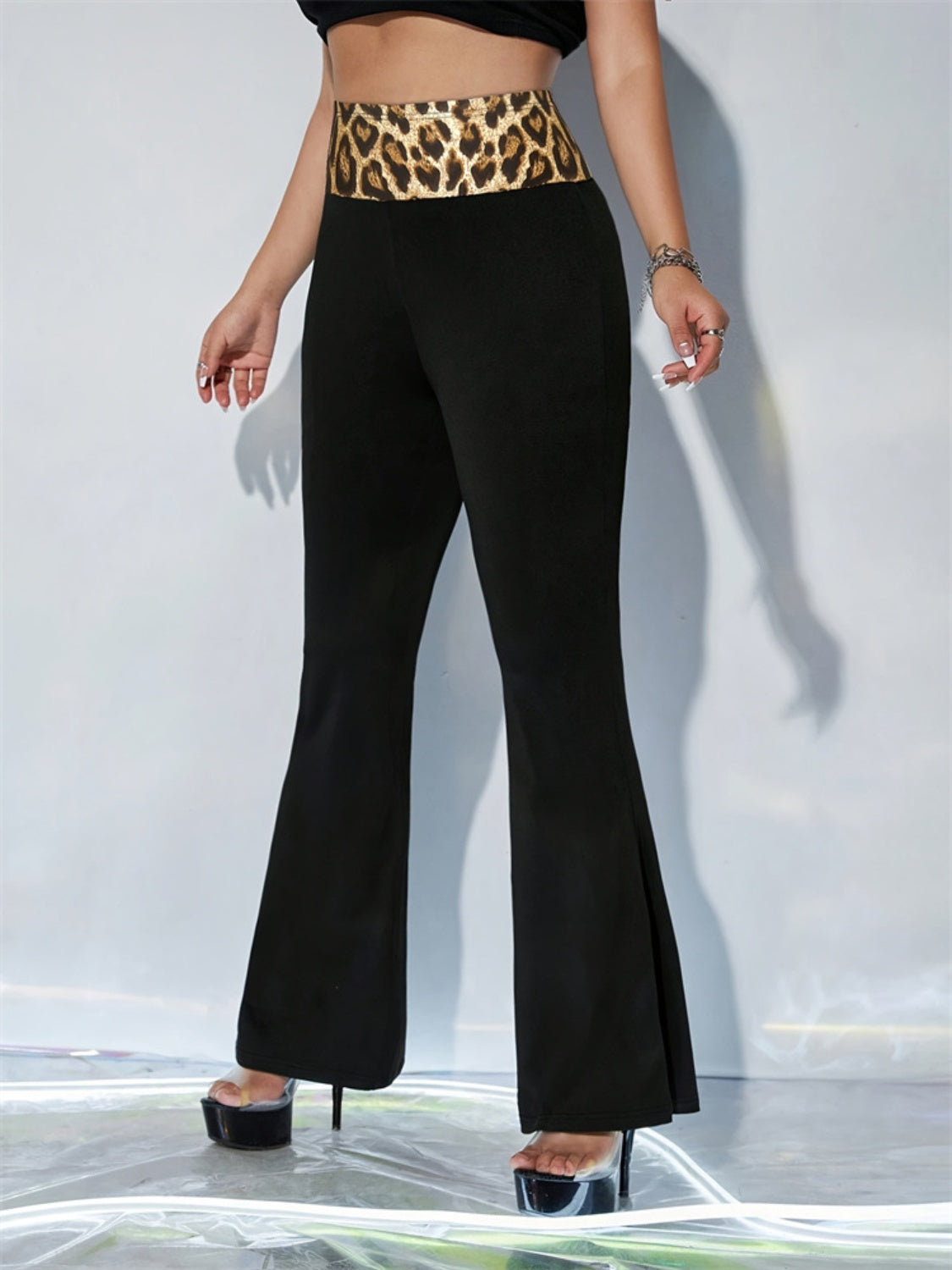 Black flare trousers with a bold leopard print waistband.