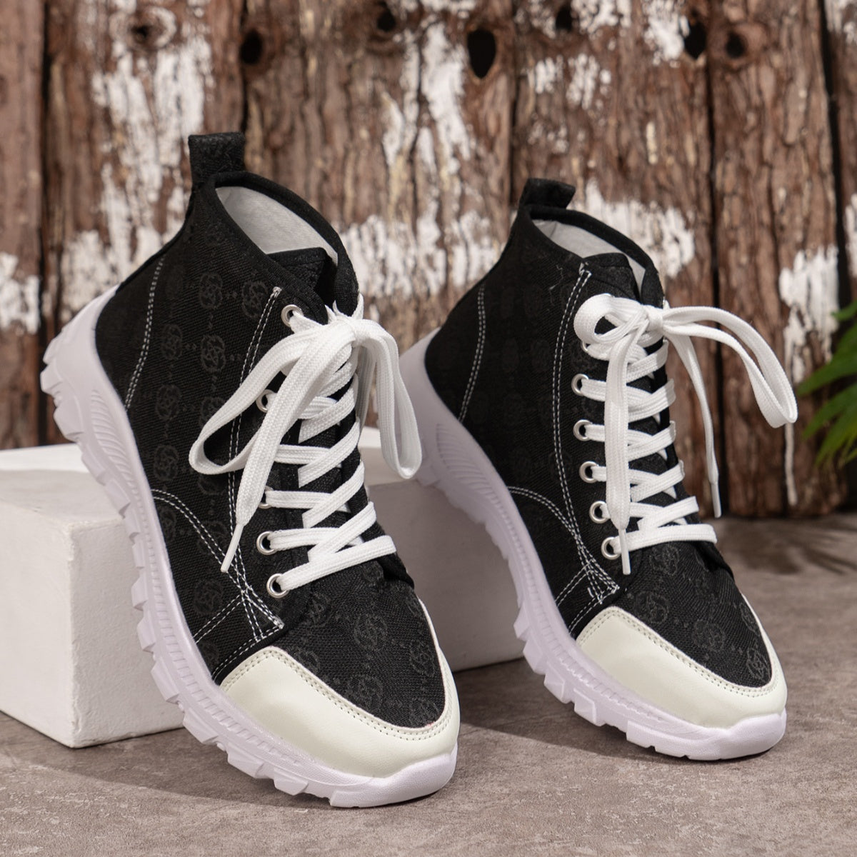 Black canvas high-top sneakers with white laces and chunky soles.