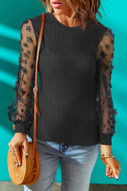 Black knit blouse with sheer floral appliqué sleeves