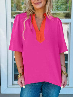 Textured pink blouse with orange V-neck detail and half sleeves.