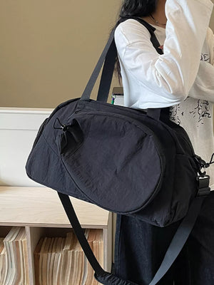 Black nylon sport duffle bag with adjustable strap and front pocket detail.