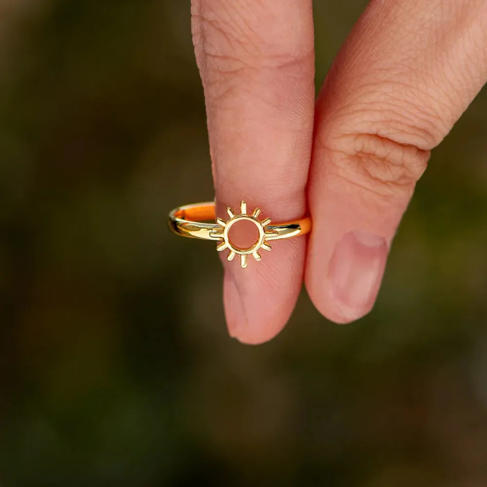 Gold sunburst signet ring with a subtle sun detail.