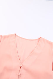 Peach button-down blouse with V-neck and two visible buttons.