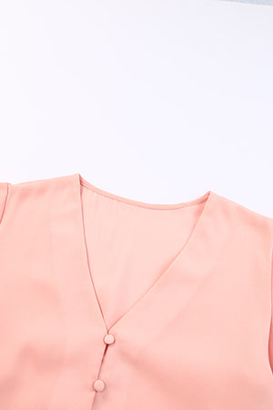 Peach button-down blouse with V-neck and two visible buttons.