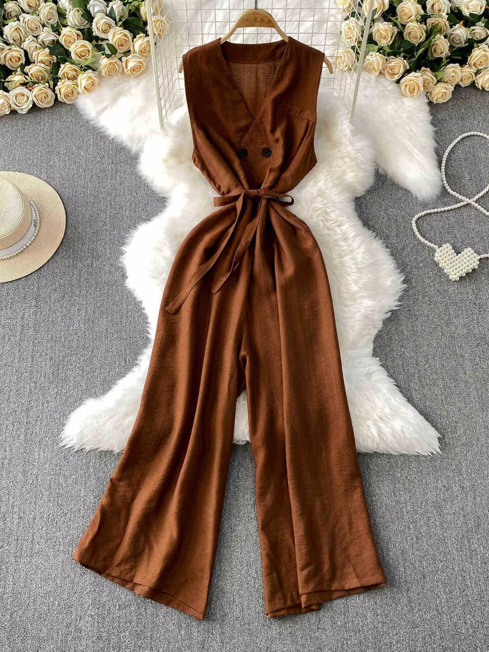 Brown V-neck wide leg jumpsuit with belted waist and button detail