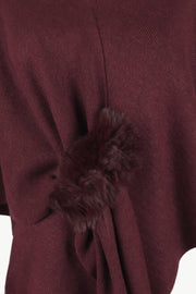Wine knit cape with faux fur trim detail.