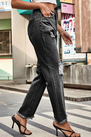 Distressed hem straight leg jeans in dark wash denim with ripped details.