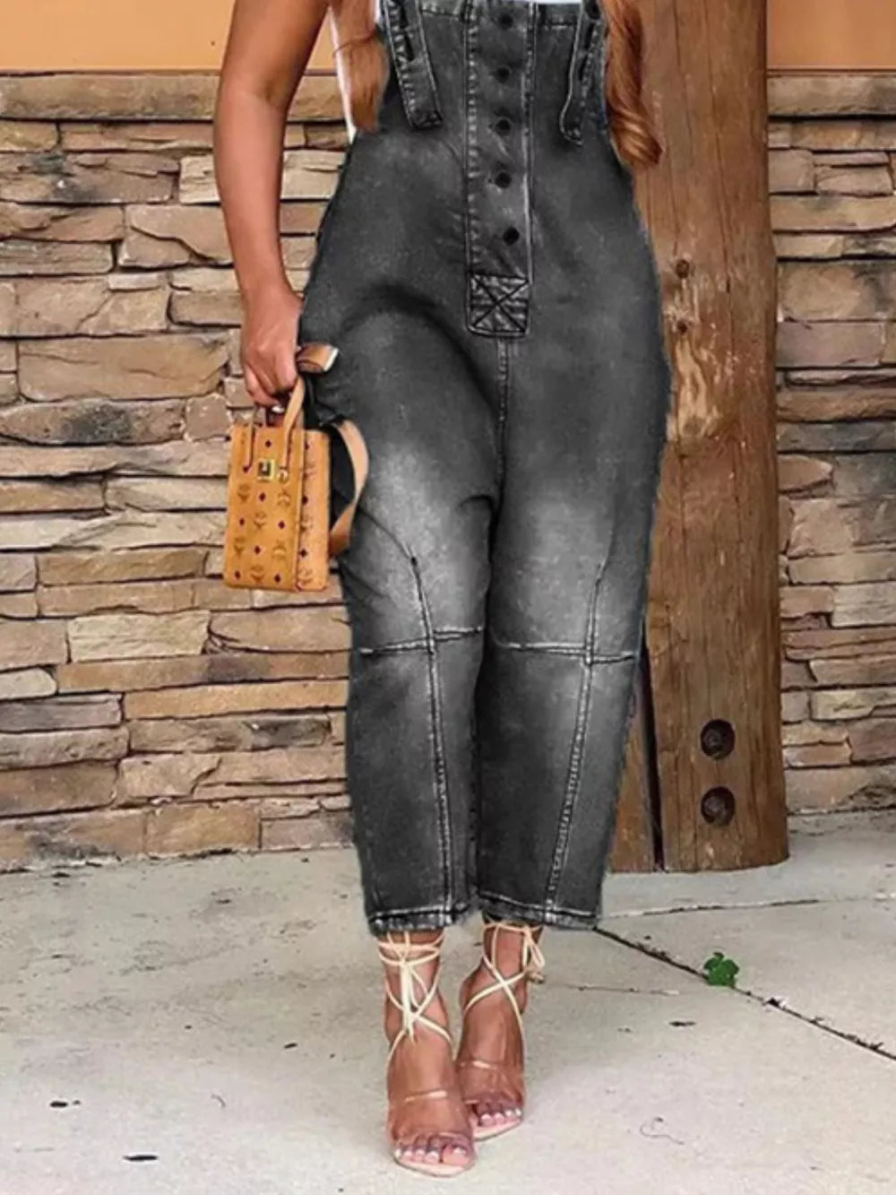 Black denim overalls with button-front and adjustable straps, cropped leg.
