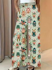 Pastel yellow wide-leg maternity trousers with a colorful beetle print and pockets.
