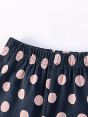Baby shorts with navy blue and pink polka dots and elastic waistband.