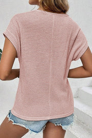 Dusty pink waffle knit top with short sleeves and lace yoke detail, styled with denim shorts.