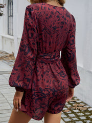 Floral wrap romper in Dark Brown with blouson sleeves and a tie waist.