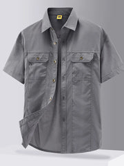 Grey short-sleeve button-down shirt with two chest pockets and cotton fabric.