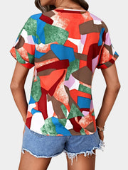 Geometric print V-neck blouse with short sleeves in multicolor abstract pattern.