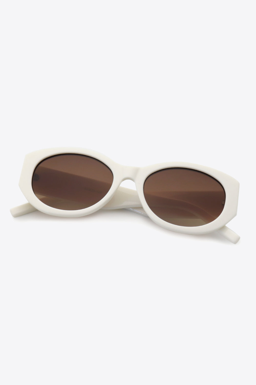 Sculpted oval frame sunglasses in white with brown lenses.