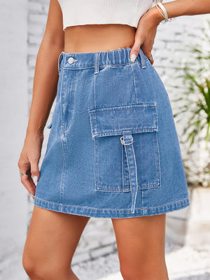 Denim A-line mini skirt in medium wash with utility cargo pocket and button closure.
