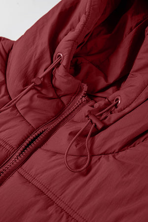 Burgundy quilted hooded puffer vest with adjustable drawcords and zipper detail.