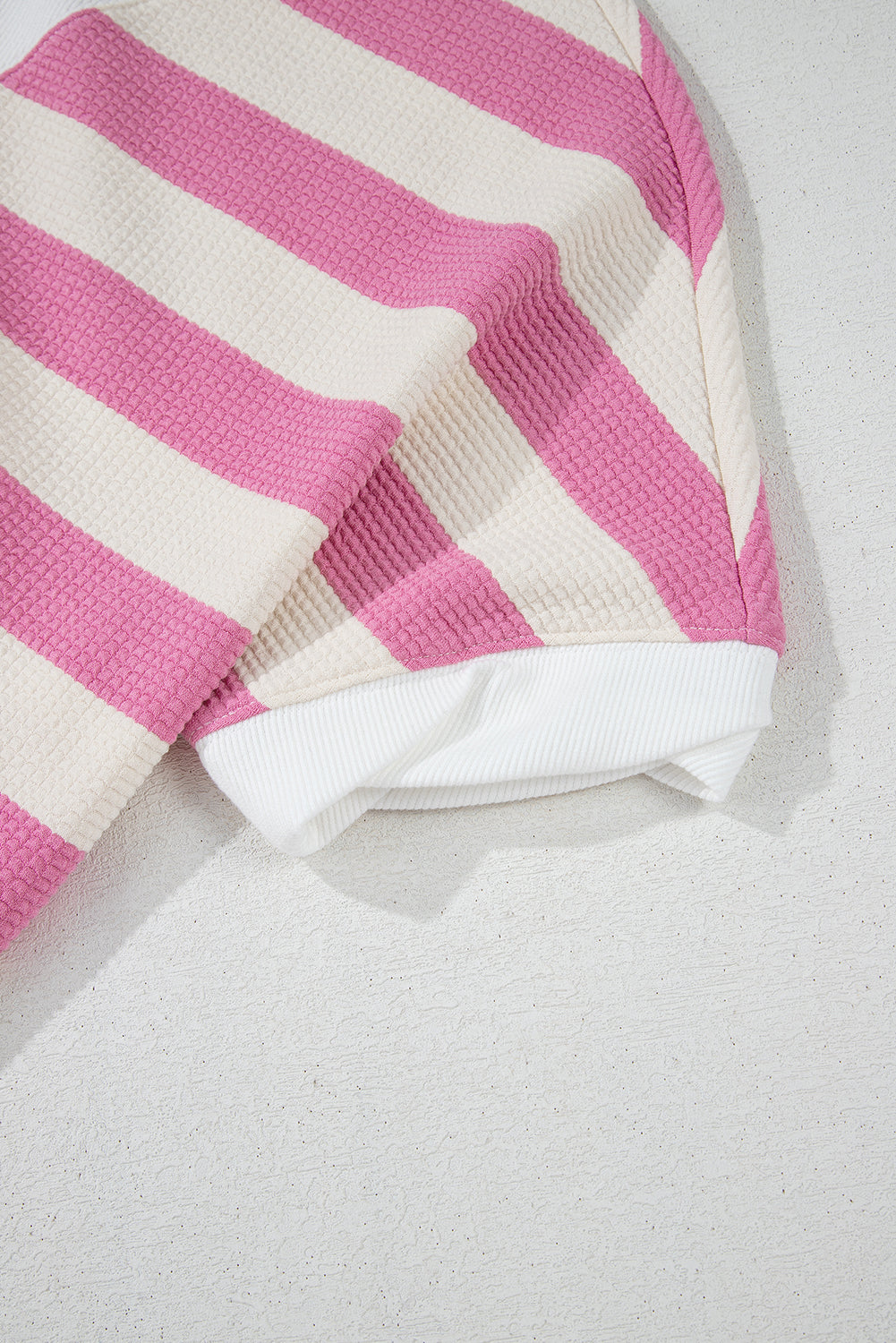 Pink and cream striped waffle knit top with white ribbed hem and cuffs.