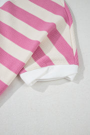 Pink and cream striped waffle knit top with white ribbed hem and cuffs.