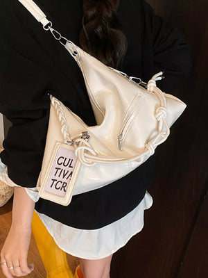 White shoulder bag with braided strap detail and knotted accents.