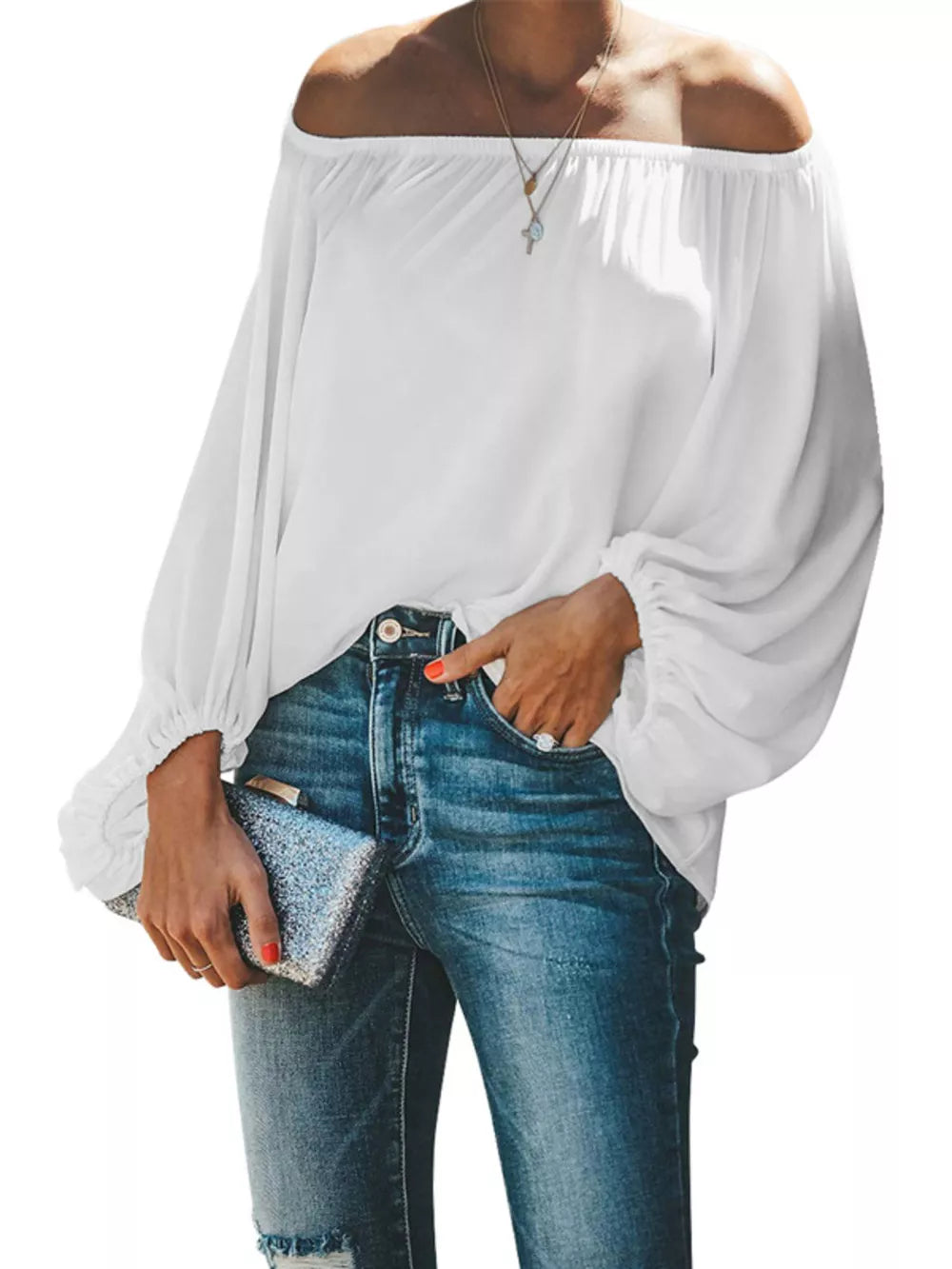 White off-shoulder blouse with balloon sleeves and elastic cuffs, styled with jeans.