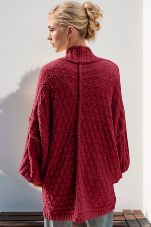 Textured bouclé cocoon cardigan in deep red with balloon sleeves and a mock neck.