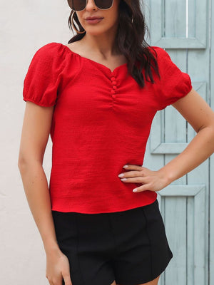Red ruched button-front puff sleeve blouse with a textured fabric.