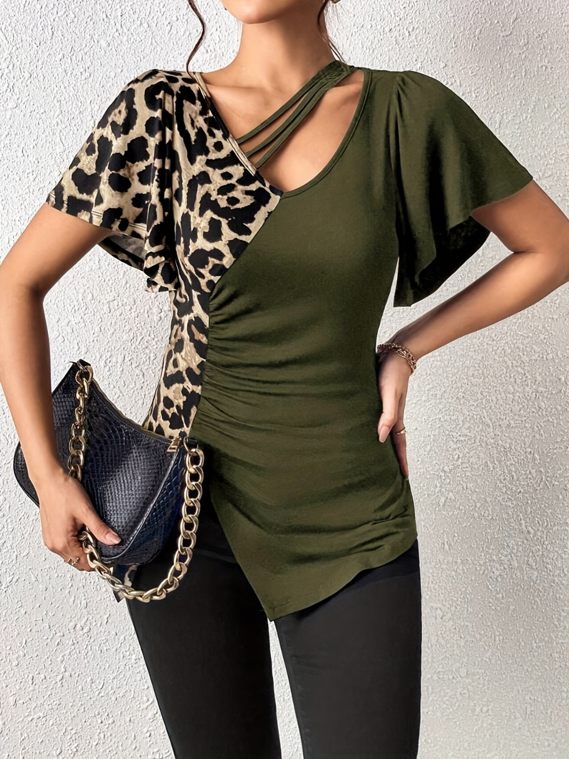 Moss green asymmetric top with leopard print panel, ruched side, and cutout neckline.