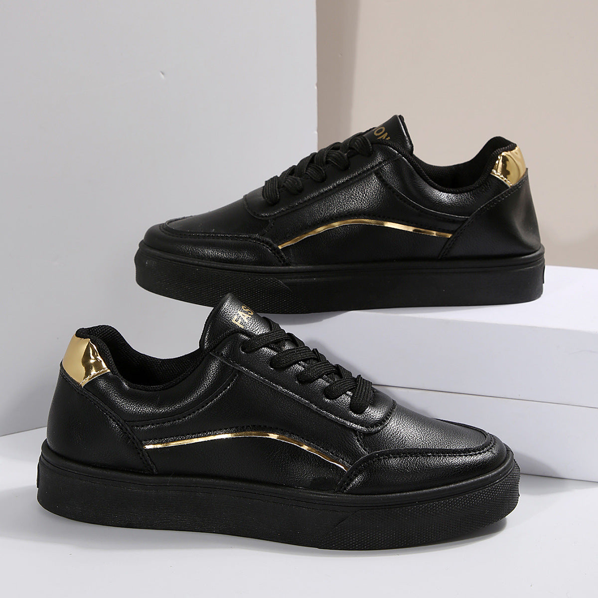 Black lace-up casual sneakers with gold accents and premium material.