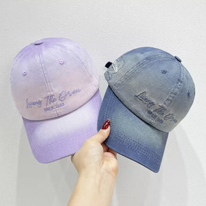 Gradient embroidered cotton baseball caps in light purple and dark blue denim.