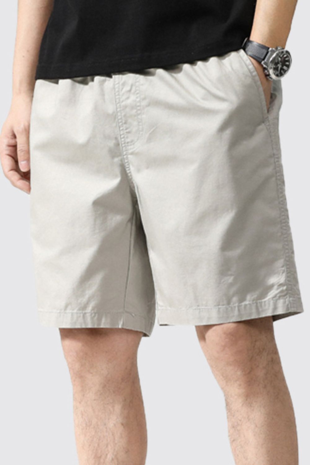 Light gray casual chino shorts with pockets and elastic waist, above the knee length.