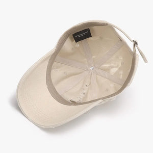 Shredded canvas baseball cap in ivory with distressed details and adjustable strap.