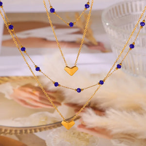Gold layered necklace with heart pendants and blue beads