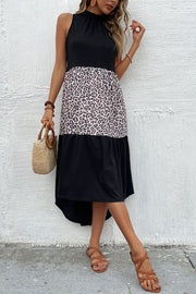 Tiered leopard panel halter dress in black and leopard with a ruffled neckline and high-low hem.