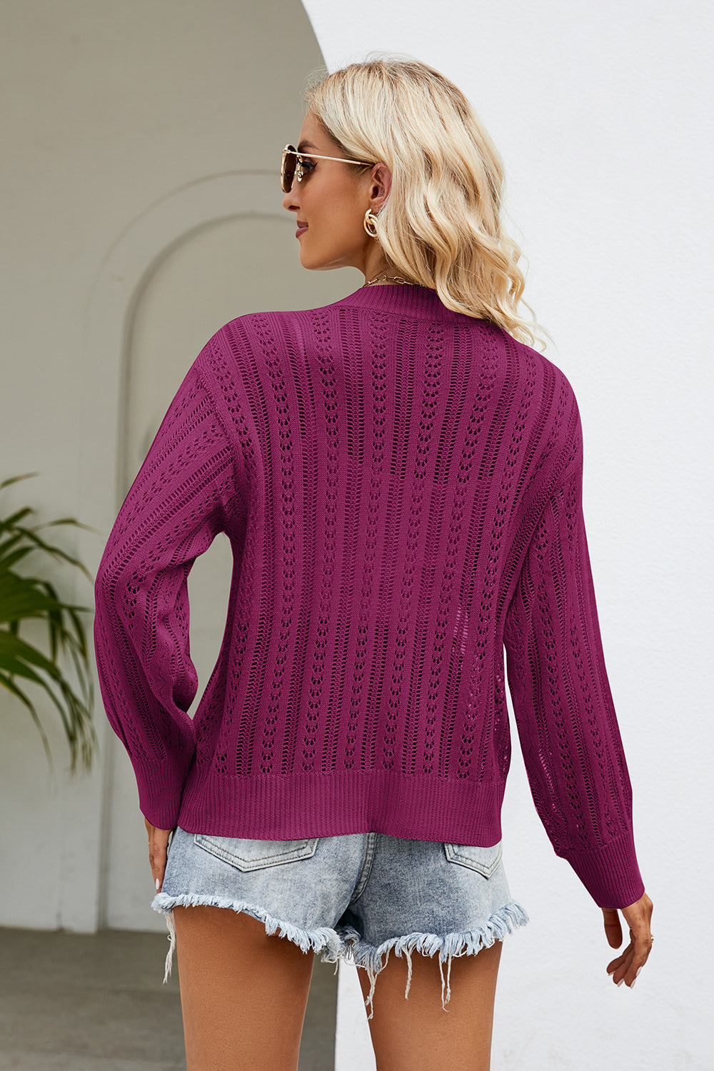 Openwork knit cardigan in cerise with button front and long sleeves.