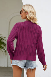 Openwork knit cardigan in cerise with button front and long sleeves.