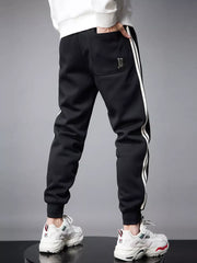Black cotton joggers with white side stripes and a back pocket detail.