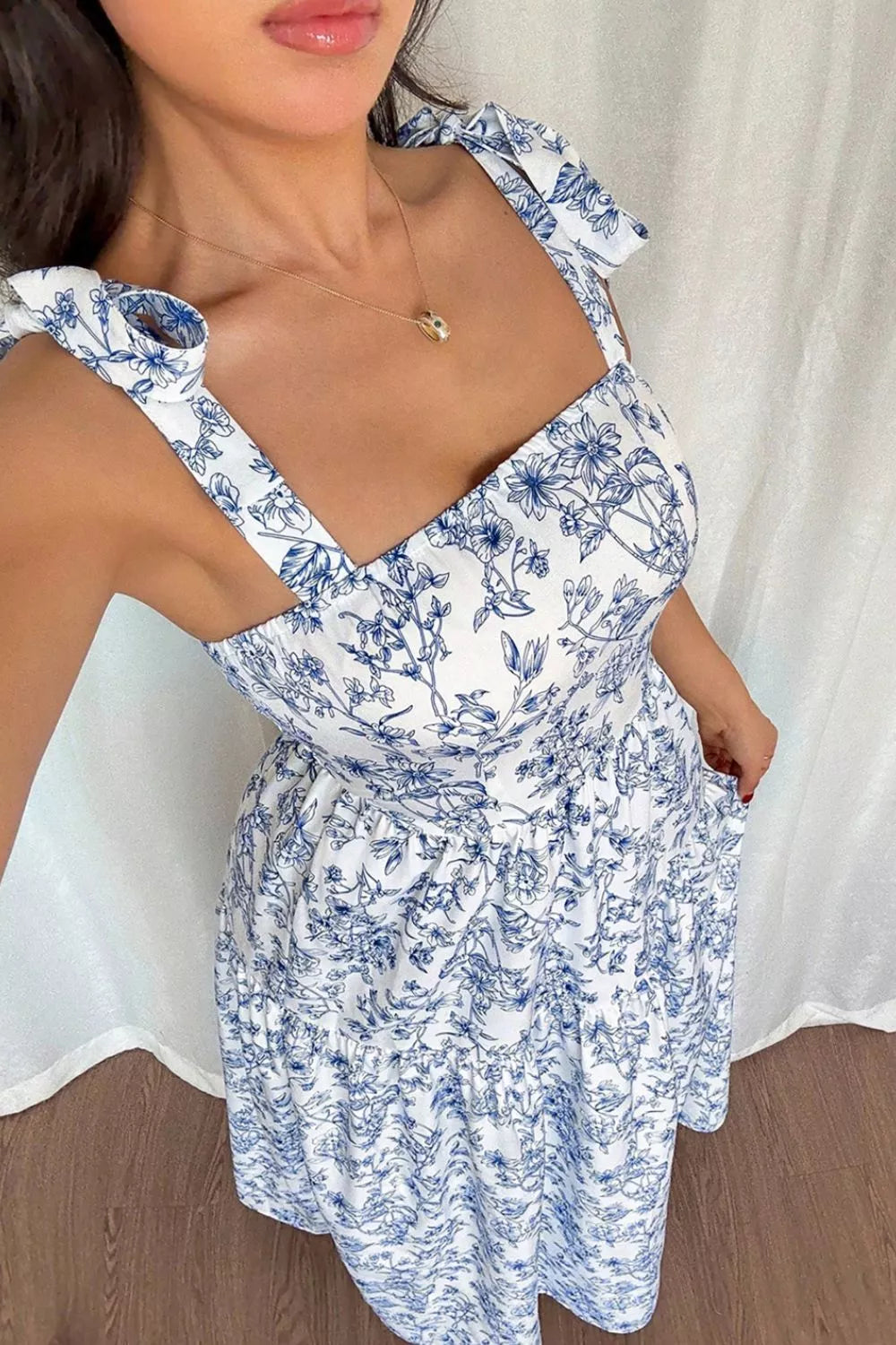 Maxi dress with blue floral print, square neckline, tie straps, and pockets.
