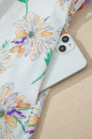 Floral print belted sleeveless dress with a white background and purple, orange, and green flowers.