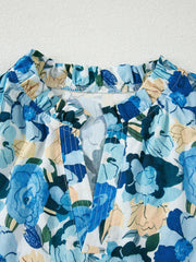 Vibrant floral print cotton blouse with ruffled V-neck and puff sleeves.