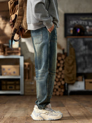 Men's blue cotton straight leg jeans with vintage wash and paneled detail.