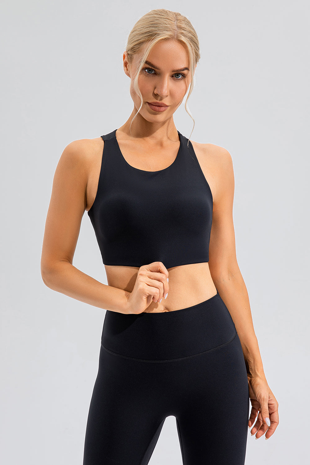 Black asymmetric cutout sports bra with racerback and scoop neckline.
