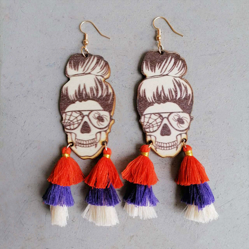 Skull bun drop earrings with orange, purple, and white tassels and spiderweb glasses.