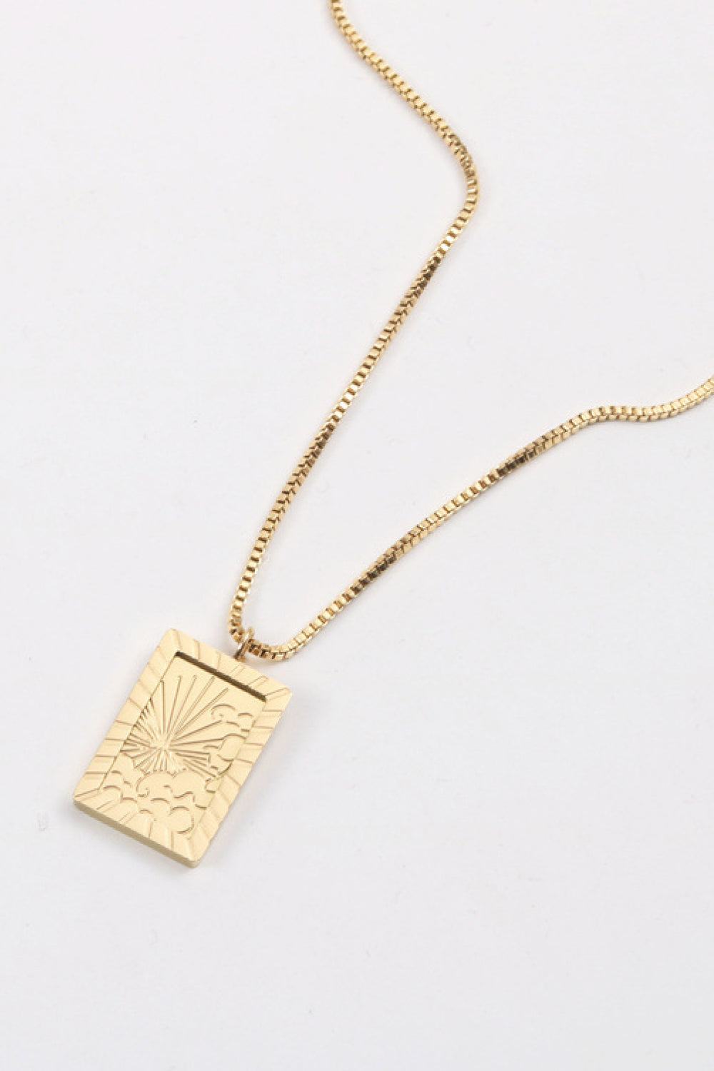 18K gold-plated celestial pendant necklace with sunburst detail on a box chain.
