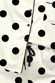 Polka dot pajama set with button-up top and drawstring waist pants.