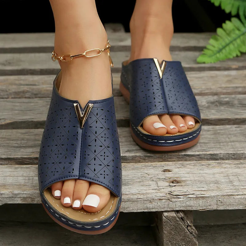 Navy laser-cut leather platform slides with V-shaped gold accent and open toe.