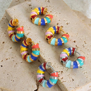 Rainbow enamel segmented hoop earrings in gold and silver with colorful stripes.