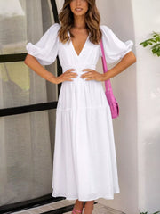 White midi dress with V-neck, tiered skirt, and voluminous puff sleeves.